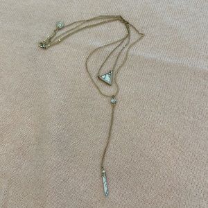 Gold necklace with white and black stone